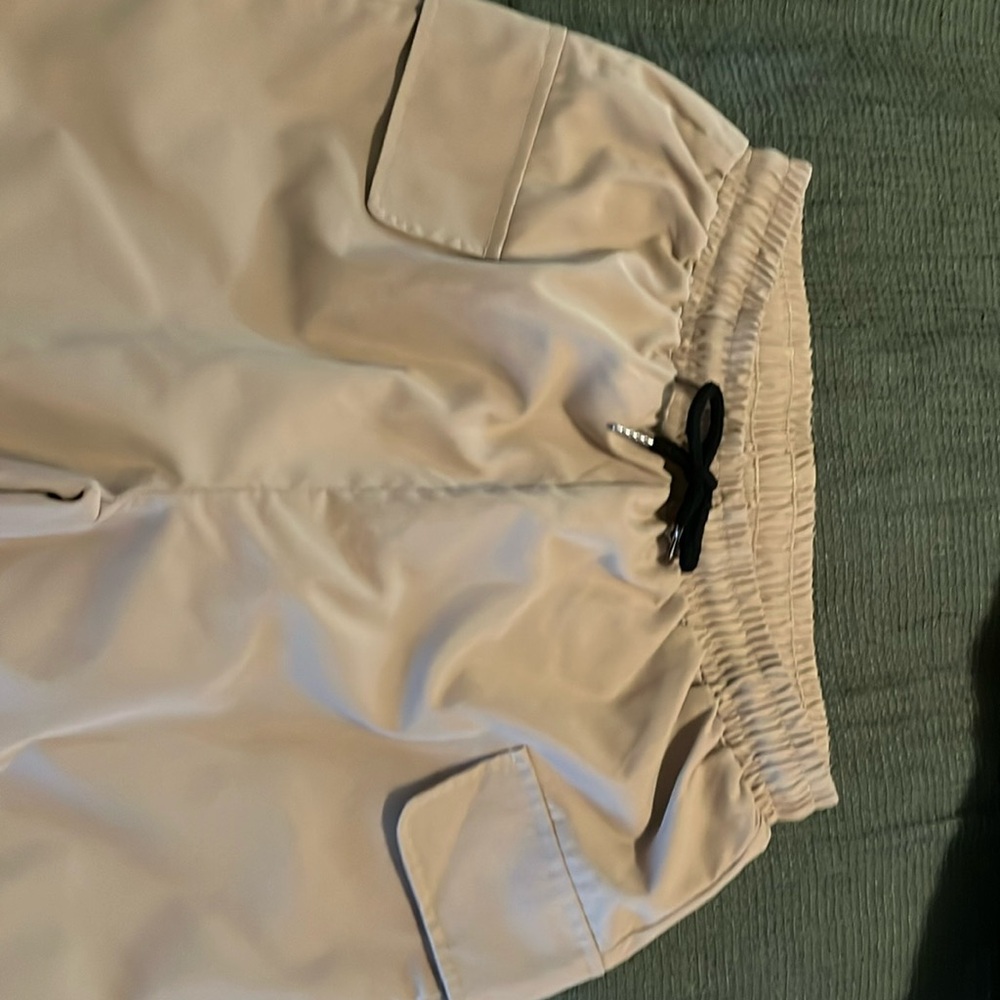 Tan pull on cargo pants, with a cuffed ankle.